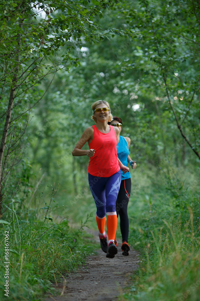 Two sportswomen training in woods