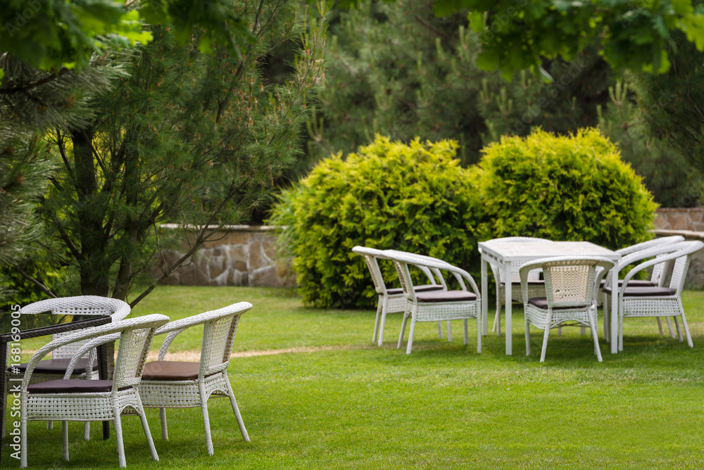 White garden furnituse sofa armchair table on the lawn
