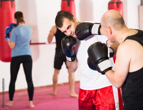 Positive sportsmen competing in boxing gloves © JackF