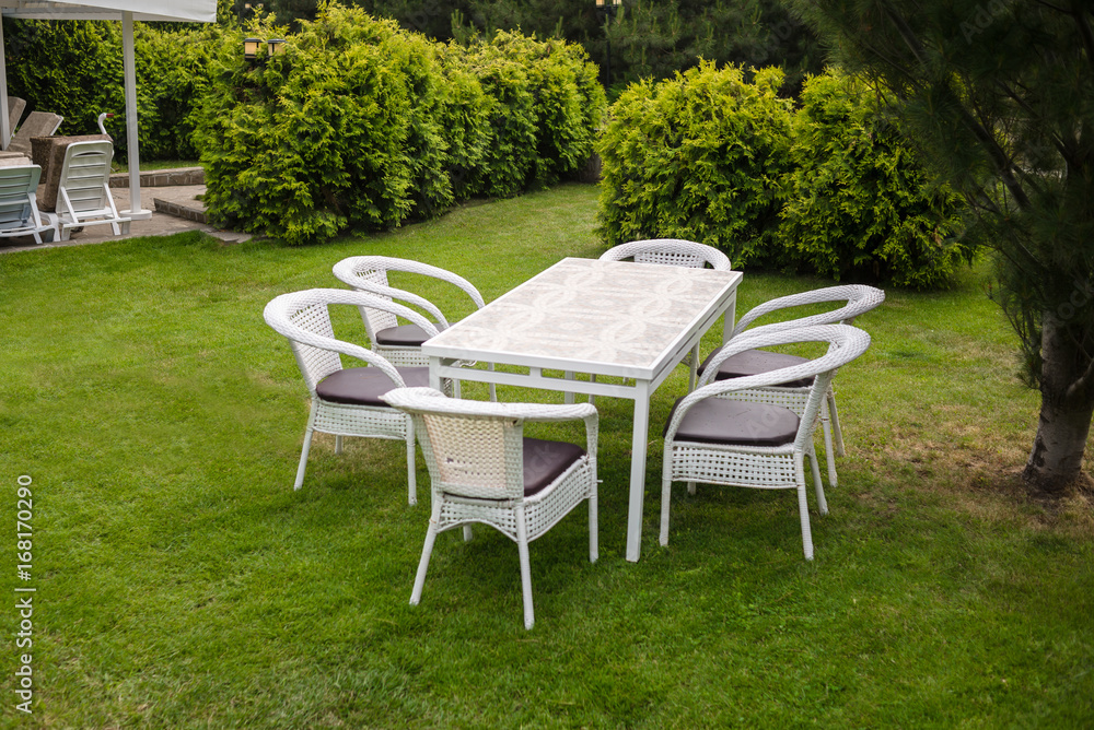 White garden furnituse sofa armchair table on the lawn White garden furnituse sofa armchair table on the lawn