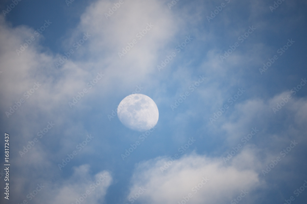 Moon behind slight clouds middle of day Moon behind slight clouds middle of day
