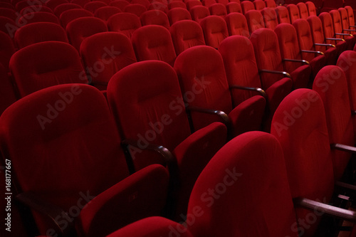 Empty rows of red theater or movie seats, side view