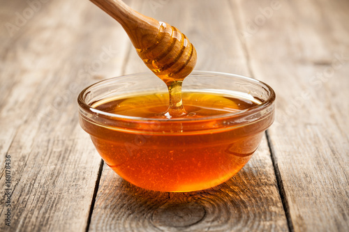 Honey in glass bowl on wooden table