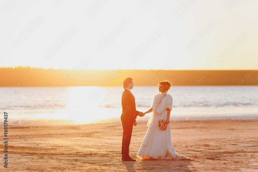 Groom and bride on a walk outdoors at the sea