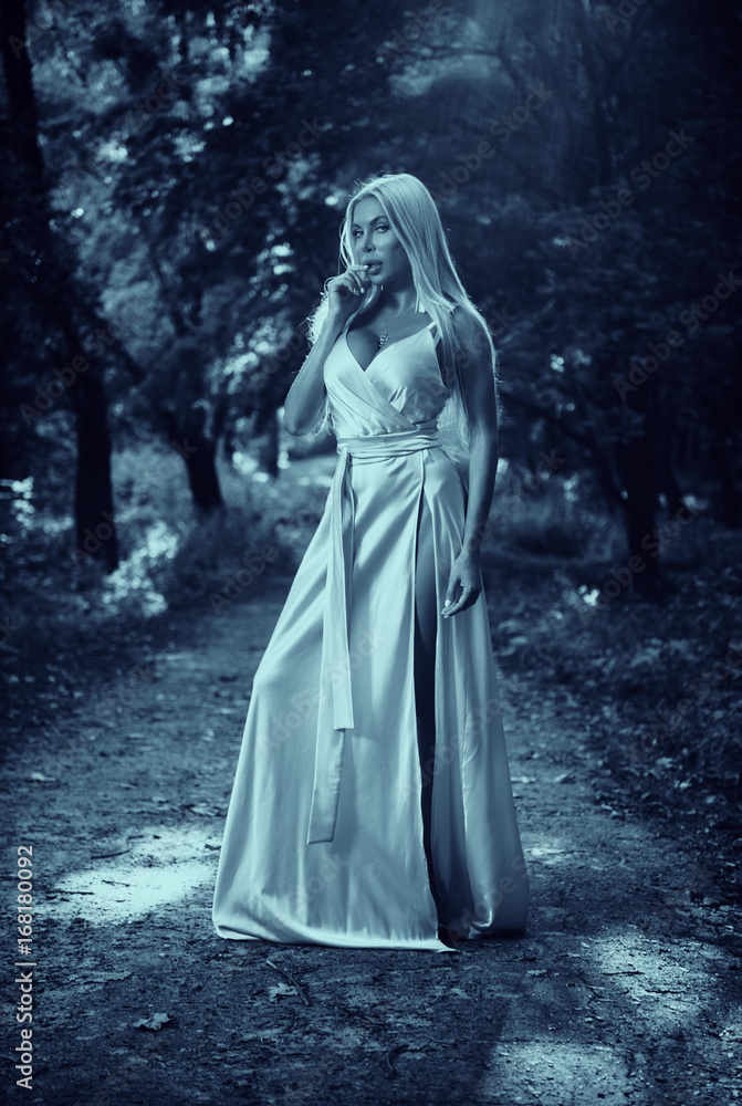 Girl in a long dress in the park. Blonde. Summer.