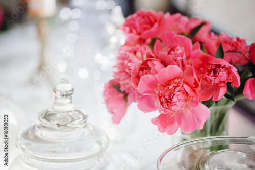 Bouquet of dark pink peonies stands in tha vase