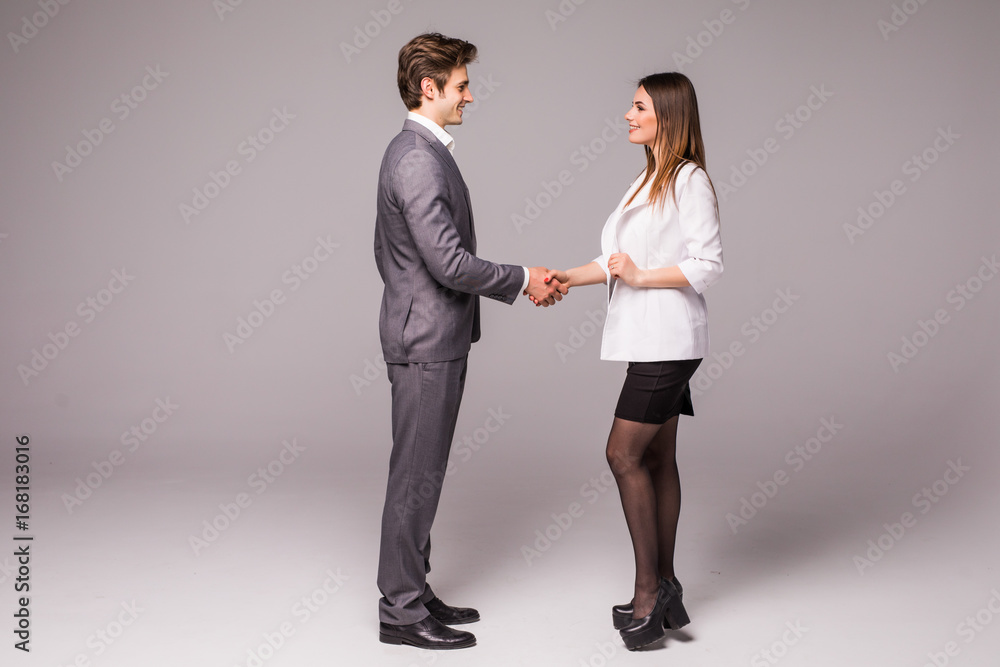 Fototapeta premium Man and woman business handshake isolated on gray background. Businessman and business woman handshake.