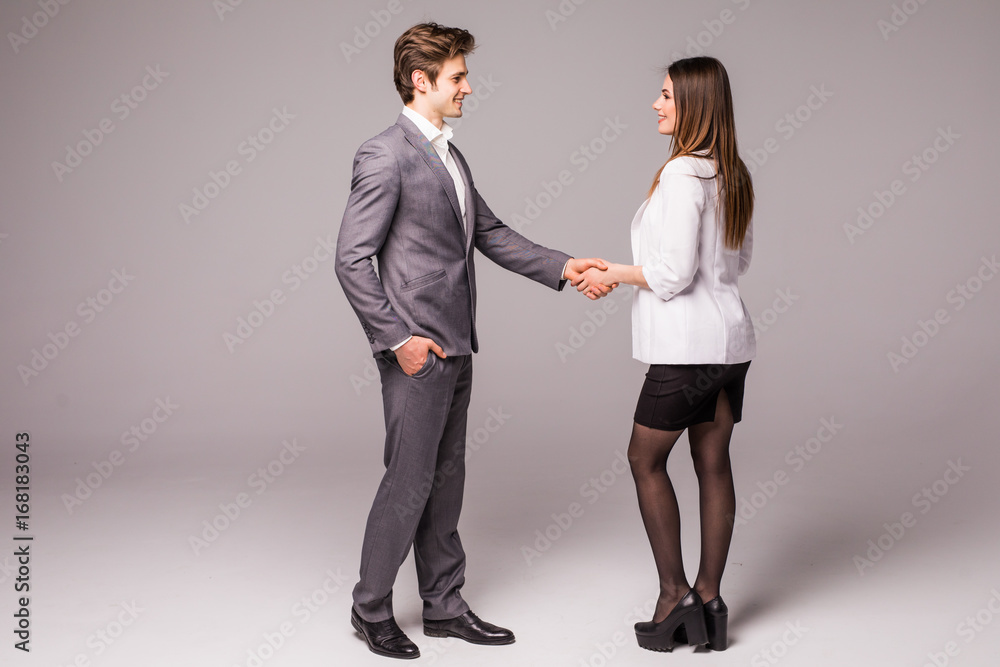 Fototapeta premium Man and woman business handshake isolated on gray background. Businessman and business woman handshake.