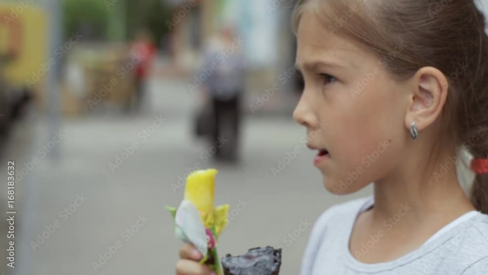 Little girl eating ice cream on the street Little girl eating ice cream on the street
