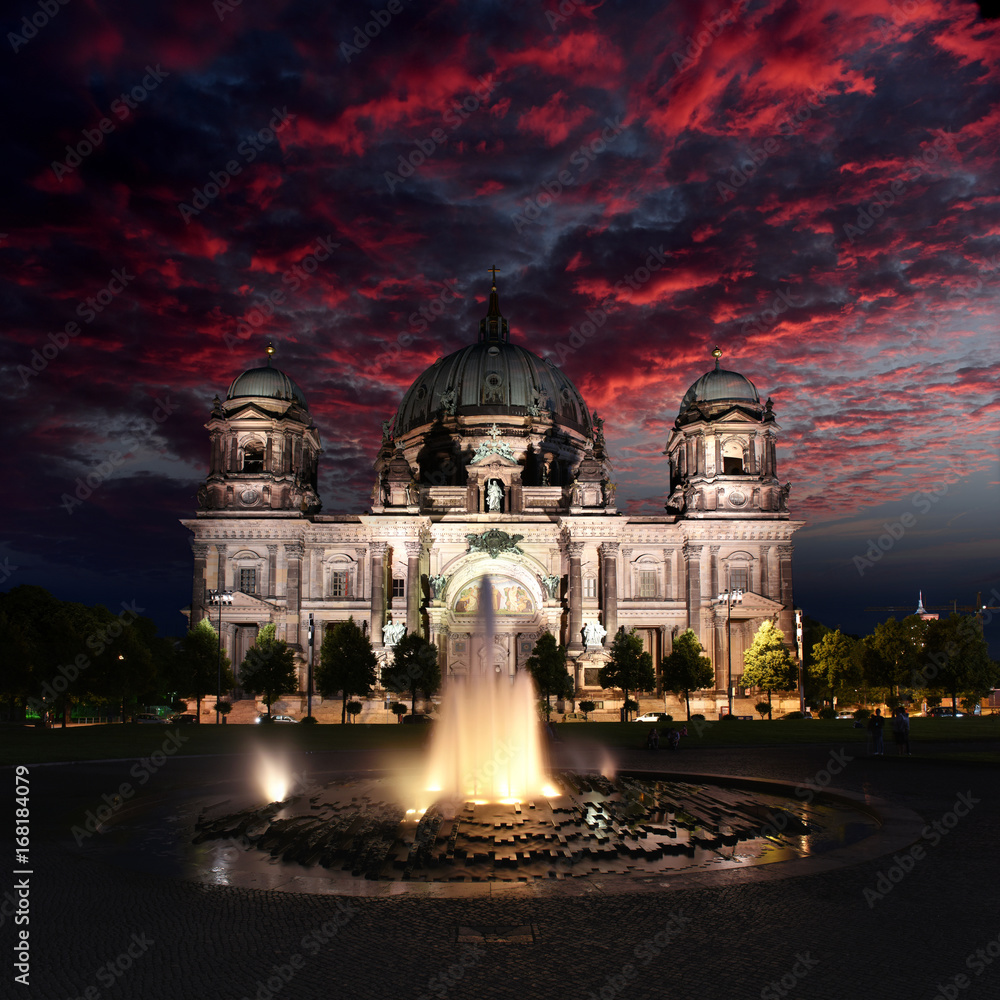 Berlin, Germany - View of illuminated Evangelical Cathedral located on the Museum Island while sunset with red cloudy sky