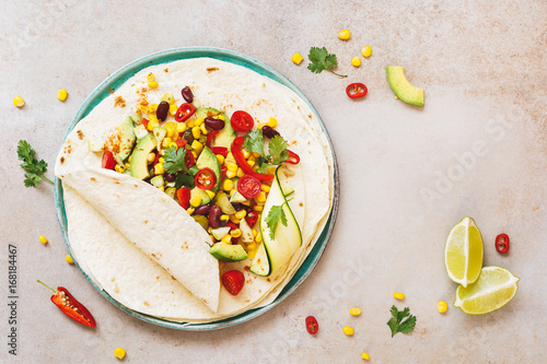 Vegetarian taco wraps. Vegetable tacos with ingredients on rustic surface. Top view, blank space photo