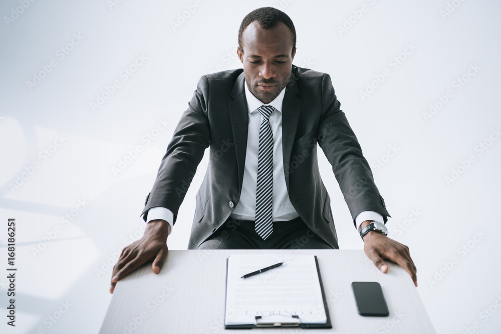 african american businessman at workplace with document african american businessman at workplace with document