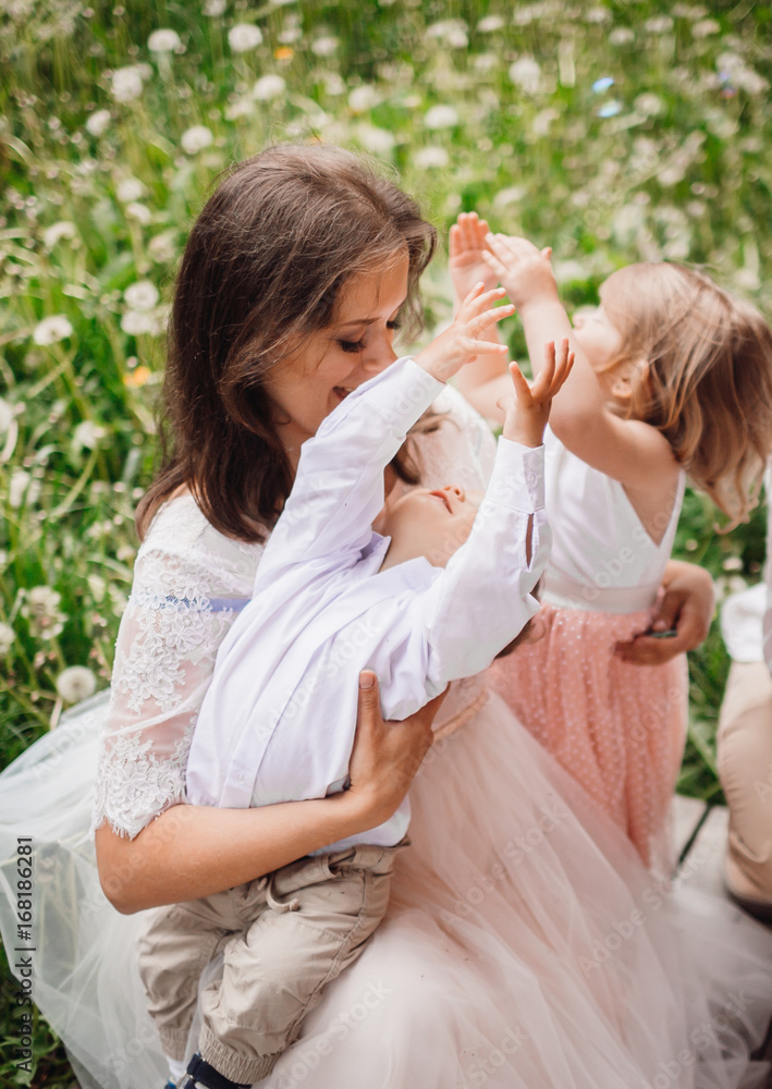 Obraz premium Mother hugs her pretty little children