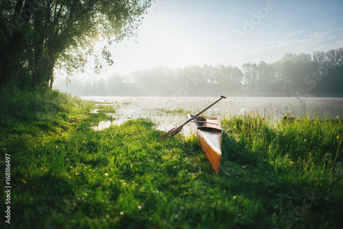 canoe with paddle on coast of lake