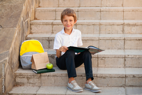 Children reading books. Schoolboys doing homework outdoors.