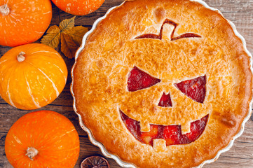 Delicious homemade pie for halloween with a filling of pumpkin-strawberry jam and peaches