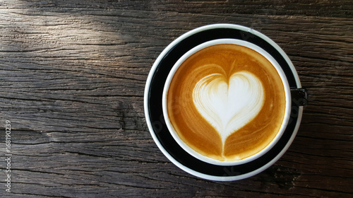 Cup of Latte art with heart shape on old wooden background,top view , mobile phone photography