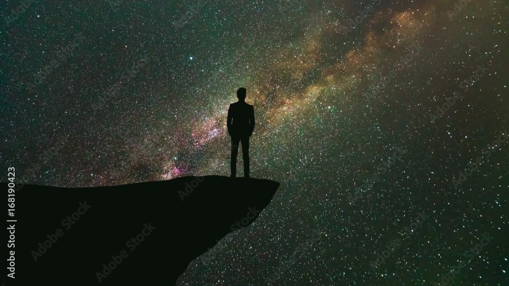 The man stand on the mountain on the starry sky background. time lapse The man stand on the mountain on the starry sky background. time lapse