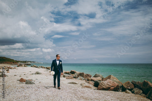 Groom in a suit and a tie for a walk at the sea