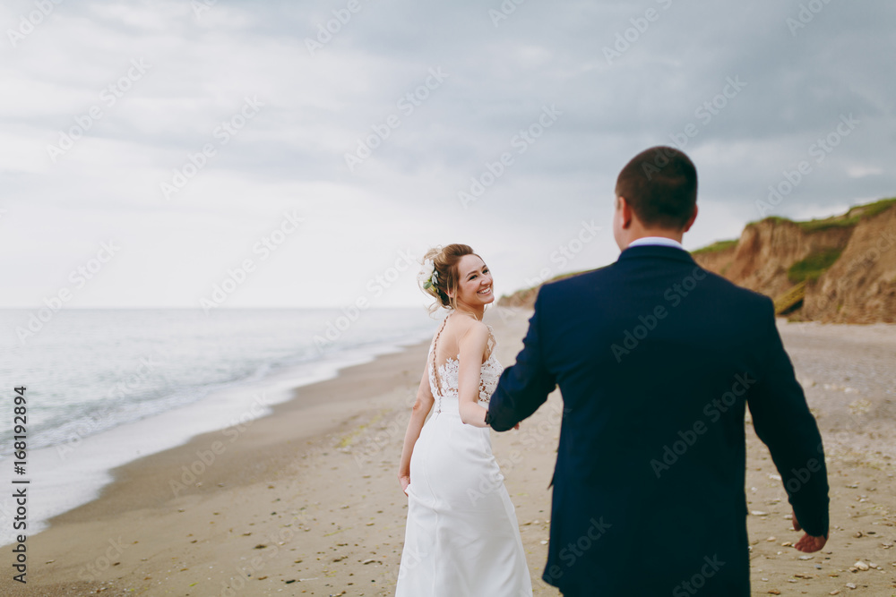 Groom and bride on a walk outdoors at the sea