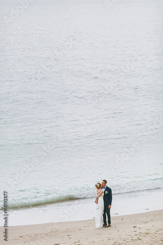 Groom and bride on a walk outdoors at the sea © ViDi Studio