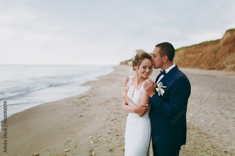 Groom and bride on a walk outdoors at the sea Groom and bride on a walk outdoors at the sea