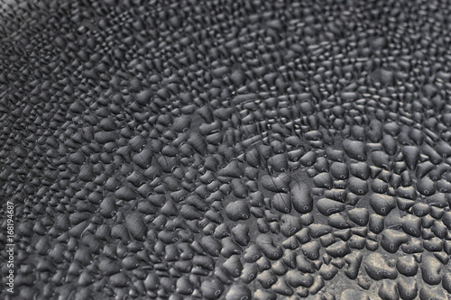 Closeup image of condesation drops in a grey metallic surface.