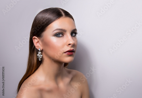 Fashionable portrait of a girl model. Fashion, accessories, evening wet effect makeup.