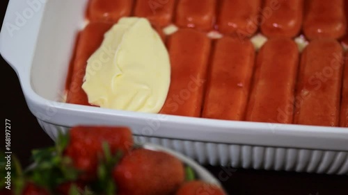 Female hands smeared cream on cake. Strawberry tiramisu cake photo