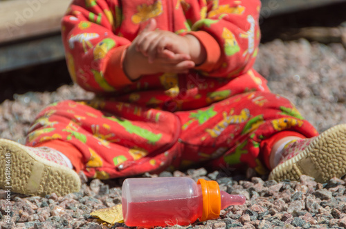 closeup of the hands of the baby with a bottle. © dmitrypk