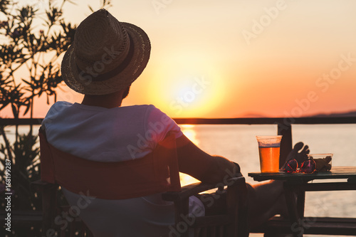 Young man enjoying sunset at a beach bar