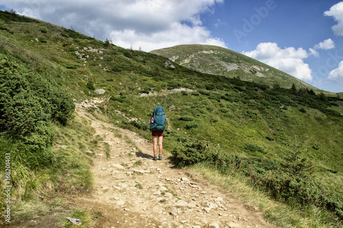 A woman is traveling in the mountains