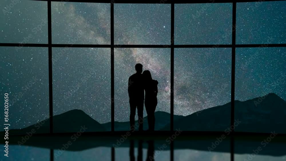 The couple stand near a window against the meteor shower in the sky. time lapse The couple stand near a window against the meteor shower in the sky. time lapse