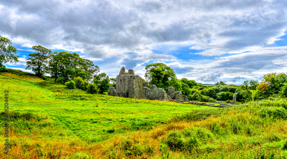 Obraz premium Inch Abbey with a blue sky in Northern Ireland. Monastery ruins in Downpatrick. Co. Down. Travel by car in summer.