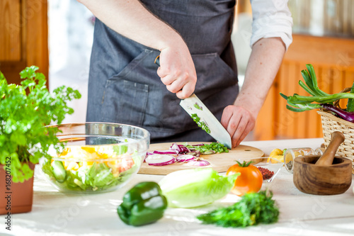 Chef cutting fresh and delicious vegetables for salad