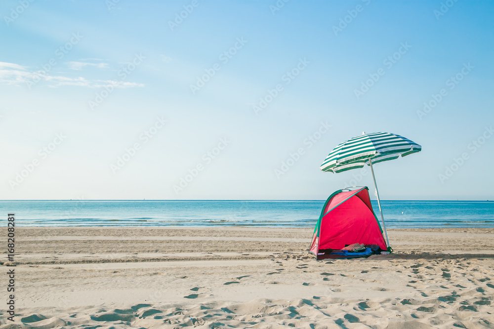 colorful of red tent and blue beach umbrella on the beach 
