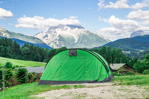 a big green tent with mountian background on camping holidays