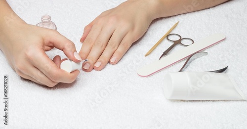 Woman makes a manicure. Beautiful female hands.