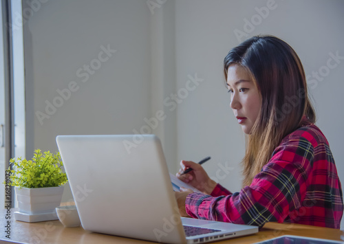 Business woman working at office with laptop, tablet and graph data documents on his desk.