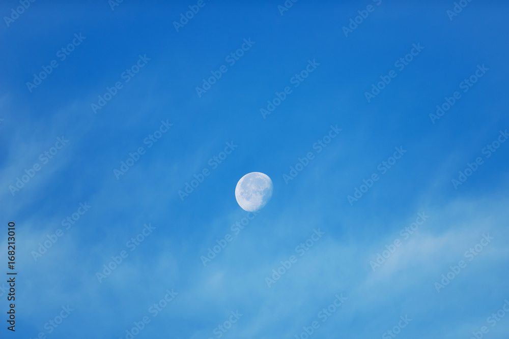 Moon with light clouds in its waning gibbous phase during daytime Moon with light clouds in its waning gibbous phase during daytime