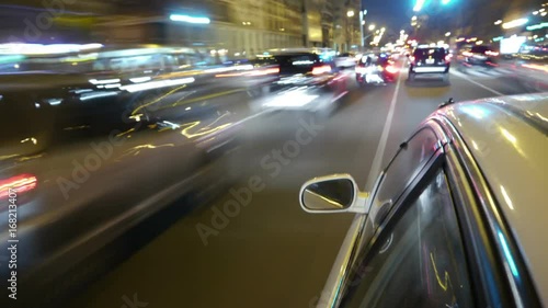 Driving a car time-lapse. Night, Camera gripped on the side / reference. POV - point of view. White car ride. City, blurred motion, fast driving. HD. Hyperlapse