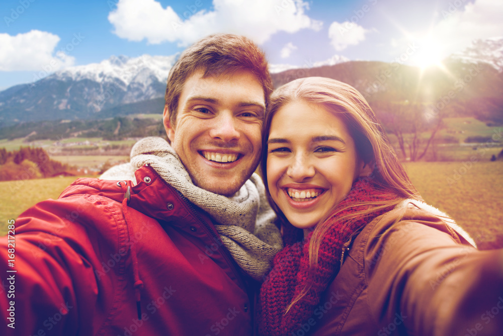 happy couple taking selfie over alps mountains happy couple taking selfie over alps mountains