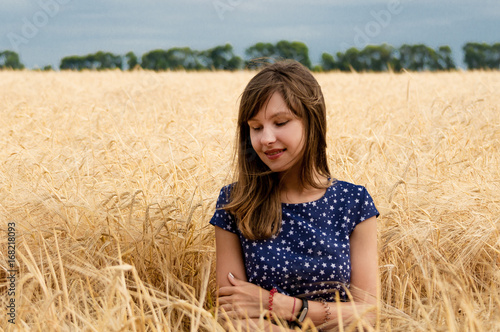 Happy young woman in golden wheat field