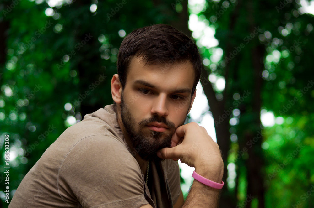 young bearded hipster man. facial profile. outside in the park young bearded hipster man. facial profile. outside in the park