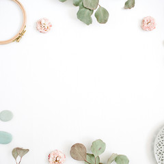 Flat lay border frame with eucalyptus branches, plate on white background. Top view floral background with space for text.