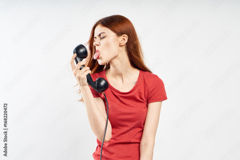 Woman on white isolated background shows the language of a landline phone, emotion, communication Woman on white isolated background shows the language of a landline phone, emotion, communication