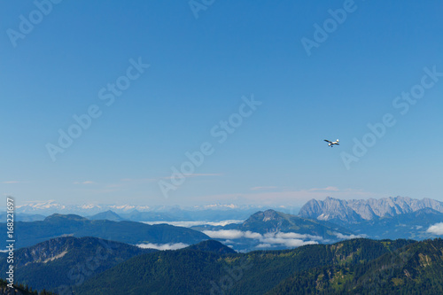 small prop plane above Mountains in Bavaria, view from Mt. Hochfelln on a summer day sunrise