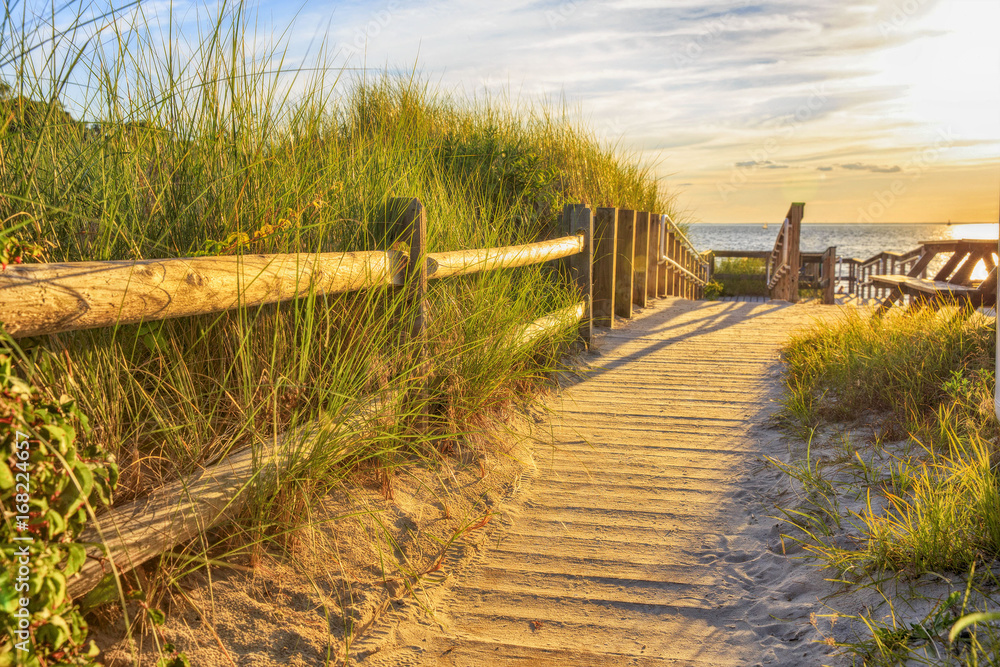 wooden path to the ocean. Ramp and wooden path to the sandy beach at sunset