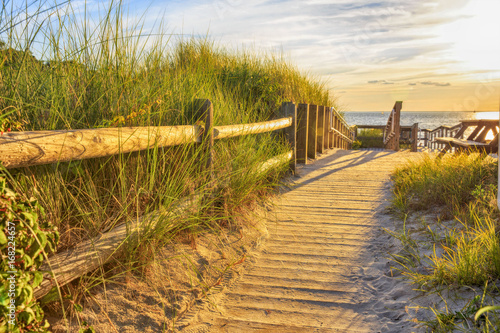 wooden path to the ocean. Ramp and wooden path to the sandy beach at sunset