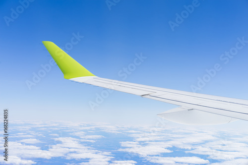 aircraft during flight wing blue sky clouds sunny